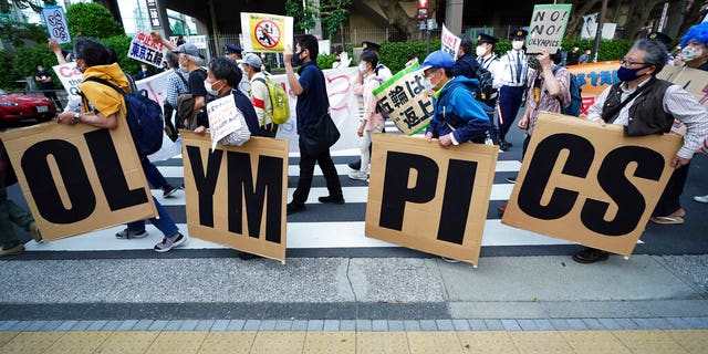 FILE: People who are against the Tokyo 2020 Olympics set to open in July, march to protest around Tokyo's National Stadium during an anti-Olympics demonstration.
