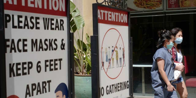 Customers wear face masks in an outdoor mall with closed businesses amid the COVID-19 pandemic in Los Angeles, June 11, 2021. (Associated Press)