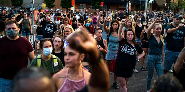 Protesters raise their fists in support during a birthday celebration and protest on West Lake Street in Uptown in honor of Deona Marie Knajdek's birthday on Wednesday, June 16, 2021, in Minneapolis. (Antranik Tavitian/Star Tribune via AP)