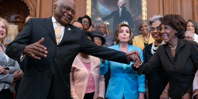 House Majority Whip James Clyburn, D-S.C., center left, reaches over to Rep. Maxine Waters, D-Calif., joined by Speaker of the House Nancy Pelosi, D-Calif., center, and members of the Congressional Black Caucus. (AP Photo/J. Scott Applewhite)