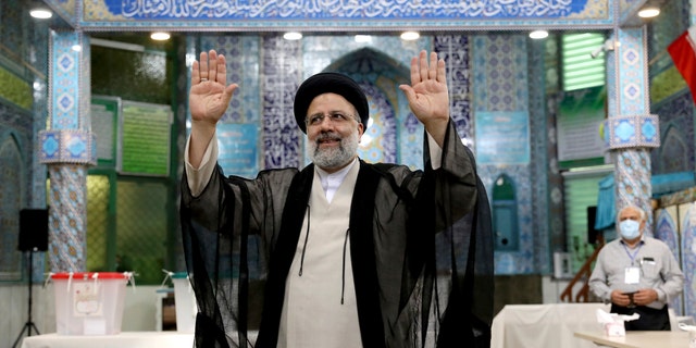 Ebrahim Raisi, a candidate in Iran's presidential elections waves to the media after casting his vote at a polling station in Tehran, Iran Friday, June 18, 2021. Iran began voting Friday in a presidential election tipped in the favor of a hard-line protege of Supreme Leader Ayatollah Ali Khamenei, fueling public apathy and sparking calls for a boycott in the Islamic Republic. (AP Photo/Ebrahim Noroozi)