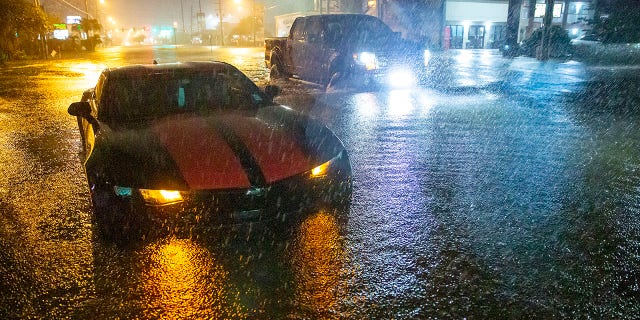 Motorists navigate a flooded Gause Boulevard in Slidell, 。, late Friday, 六月 18, 2021, as a tropical disturbance neared the Louisiana shore. Tropical Storm Claudette has formed Saturday morning along the U.S. 湾岸, bringing heavy rains and flooding to coastal states including Louisiana, Mississippi and Alabama. (Scott Threlkeld/The Advocate via AP)
