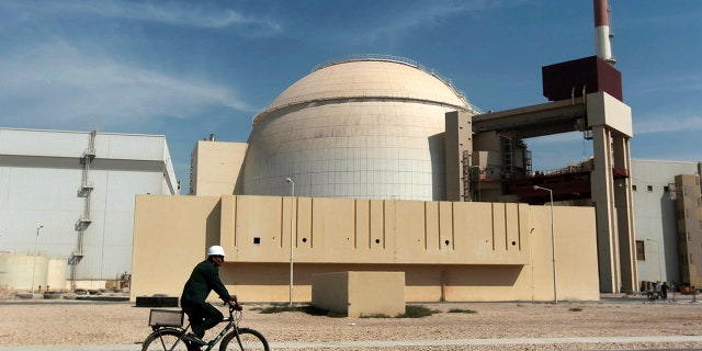 FILE - In this Oct. 26, 2010 file photo, a worker rides a bicycle in front of the reactor building of the Bushehr nuclear power plant, just outside the southern city of Bushehr. Iran’s sole nuclear power plant has undergone a temporary emergency shutdown, state TV reported on Sunday, June 20, 2021. An official from the state electric energy company, Gholamali Rakhshanimehr, said on a talk show that the Bushehr plant shutdown began on Saturday and would last "for three to four days." (AP Photo/Mehr News Agency, Majid Asgaripour, File)