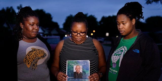 May 17, 2021: Michelle Branch, center, holds a pamphlet from the memorial service of her younger brother, Craig Elazer, 56, along with Elazer's stepdaughter, Shatia Jones, right, and niece, Alexa Sanders, in St. Louis.