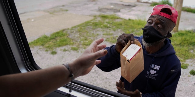 May 21, 2021: A man receives Narcan and other medical supplies from a mobile window during a harm reduction effort in St. Louis.