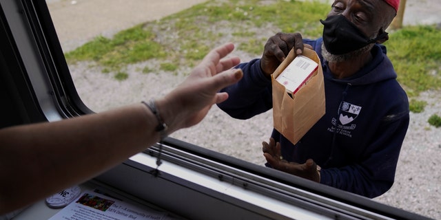 May 21, 2021: A man receives Narcan other medical supplies from a mobile window during a harm reduction effort in St. Louis.