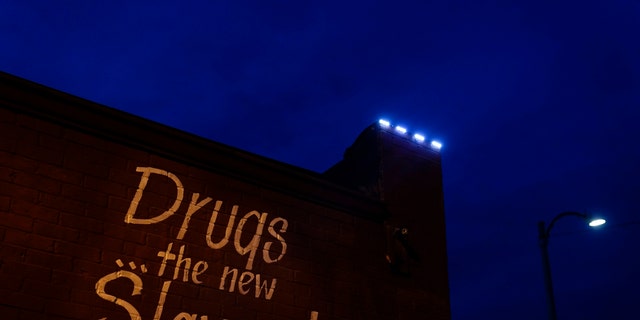 May 21, 2021: A sign painted on the side of a corner store reads, "Drugs... the new Slavery!" in St. Louis.