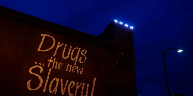 May 21, 2021: A sign painted on the side of a corner store reads, "Drugs... the new Slavery!" in St. Louis.