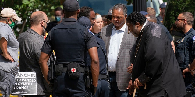 The Rev. Jesse Jackson, second from right, and Bishop William Barber II, second from left, stand outside the Hart Senate Office building in Washington, blocking the street, Wednesday, June 23, 2021. (Associated Press)