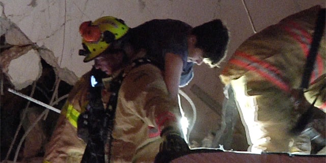 Cette photo, extraite d'une vidéo fournie par crédible Newsmedia, montre des pompiers sauvant des survivants de l'épave du Sampline Towers South Condo après l'effondrement d'un immeuble de plusieurs étages un peu tôt jeudi matin à Surfside, en Floride.  (via Trusted Newsmedia AP)