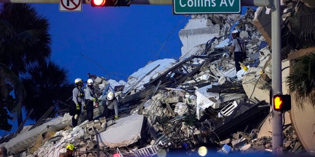 Rescue workers look through the rubble where a wing of a 12-story beachfront condo building collapsed, Thursday, June 24, 2021, in the Surfside area of Miami. (AP Photo/Lynne Sladky)