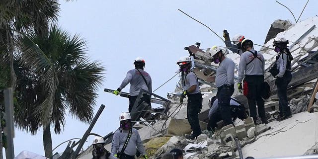 Rescue workers look through the rubble where a wing of a 12-story beachfront condo building collapsed, Thursday, June 24, 2021, in the Surfside area of Miami. (AP Photo/Lynne Sladky)