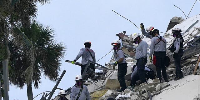 Rescue workers look through the rubble where a wing of a 12-story beachfront condo building collapsed, Thursday, June 24, 2021, in the Surfside area of Miami. (AP Photo/Lynne Sladky)