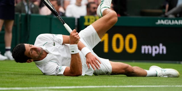 Serbia's Novak Djokovic slips on the grass during the men's singles match against Britain's Jack Draper on day one of the Wimbledon Tennis Championships in London, Monday June 28, 2021. (AP Photo/Kirsty Wigglesworth)