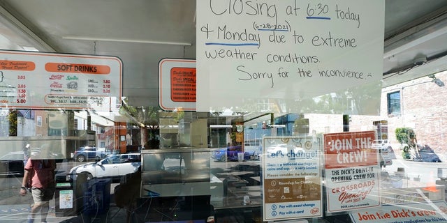 A sign in the window of the Dick's Drive-In in Seattle's Capitol Hill neighborhood is shown Monday. The walk- and drive-up restaurant, which is not air-conditioned, closed early Sunday and all day Monday due to excessive heat. (AP Photo/Ted S. Warren)