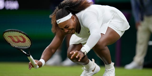 Serena Williams of the U.S. falls to the ground during the women's singles first- round match against Aliaksandra Sasnovich of Belarus on day two of the Wimbledon Tennis Championships in London, Tuesday June 29, 2021. (AP Photo/Kirsty Wigglesworth)