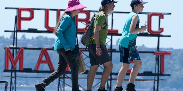 People walk near Pike Place Market, Tuesday, June 29, 2021, in Seattle. (AP Photo/Ted S. Warren)