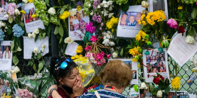 Mourners visit the makeshift memorial near the site of the collapsed condominium in Surfside, Fla., on Tuesday. (AP/Miami Herald)