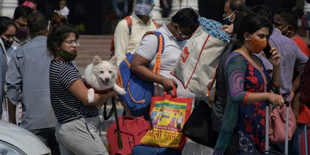 June 7, 2021: Passengers walk outside the New Delhi railway station in New Delhi.