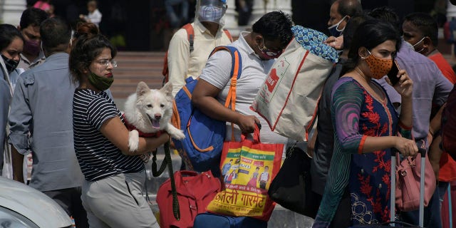 7 de junho de 2021: os passageiros caminham do lado de fora da Estação Ferroviária de Nova Delhi, em Nova Delhi. 