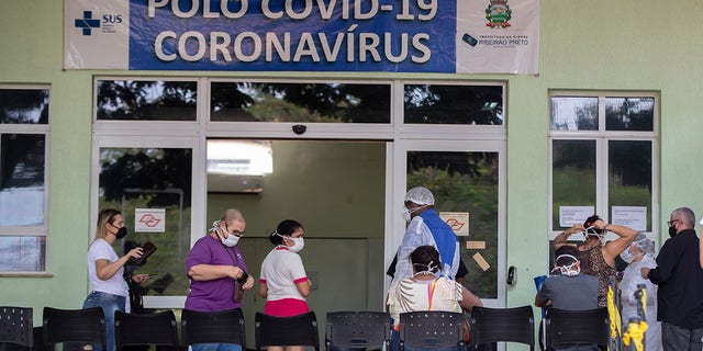 May 28, 2021: People with COVID-19 symptoms wait to be assisted outside a hospital that is at full capacity in Ribeirao Preto, Sao Paulo state, Brazil.