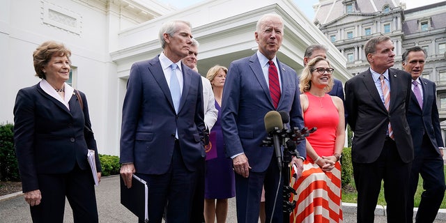 President Joe Biden, with a bipartisan group of senators, speaks Thursday June 24, 2021, outside the White House in Washington. Biden invited members of the group of 21 Republican and Democratic senators to discuss the infrastructure plan. From left are, Sen. Jeanne Shaheen, D-N.H., Sen. Rob Portman, R-Ohio, Sen. Bill Cassidy, R-La., Sen. Lisa Murkowski, R-Alaska, Biden, Sen, Joe Manchin, D-W.Va., Sen. Kyrsten Sinema, D-Ariz, Sen. Mark Warner, D-Va., and Sen. Mitt Romney, R-Utah.  (AP Photo/Jacquelyn Martin)