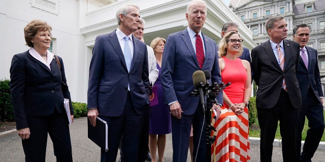 President Joe Biden, with a bipartisan group of senators, speaks Thursday June 24, 2021, outside the White House in Washington. Biden invited members of the group of 21 Republican and Democratic senators to discuss the infrastructure plan. From left are, Sen. Jeanne Shaheen, D-N.H., Sen. Rob Portman, R-Ohio, Sen. Bill Cassidy, R-La., Sen. Lisa Murkowski, R-Alaska, Biden, Sen, Joe Manchin, D-W.Va., Sen. Kyrsten Sinema, D-Ariz, Sen. Mark Warner, D-Va., and Sen. Mitt Romney, R-Utah. (AP Photo/Jacquelyn Martin)