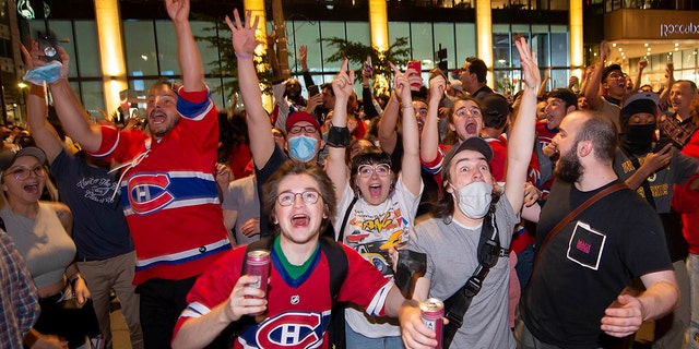 Montreal Canadiens fans celebrate on Rue Rene Levesque after the Montreal Canadiens defeated the Vegas Golden Knights in overtime in Game 6 of an NHL hockey Stanley Cup semifinal playoff series Thursday, June 24, 2021 in Montreal. (Peter McCabe/The Canadian Press via AP)