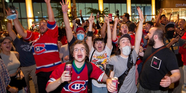 Montreal Canadiens fans celebrate on Rue Rene Levesque after the Montreal Canadiens defeated the Vegas Golden Knights in overtime in Game 6 of an NHL hockey Stanley Cup semifinal playoff series Thursday, June 24, 2021 in Montreal. (Peter McCabe/The Canadian Press via AP)