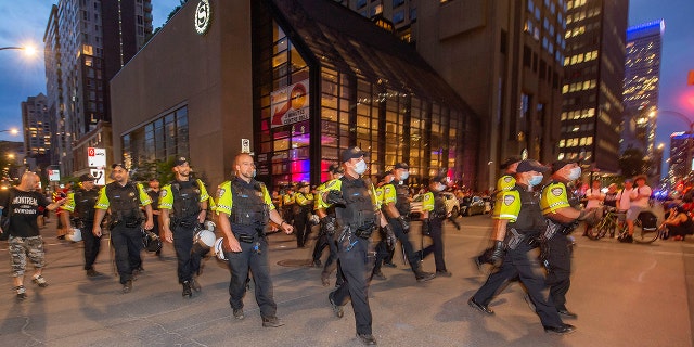 Police move around the Bell Centre, where thousands of Montreal Canadiens fans have assembled for Game 6 of an NHL hockey Stanley Cup semifinal playoff series against the Vegas Golden Knights, in Montreal, Thursday, June 24, 2021. Today is also the provincial holiday of Saint-Jean-Baptiste Day. (Peter McCabe/The Canadian Press via AP)