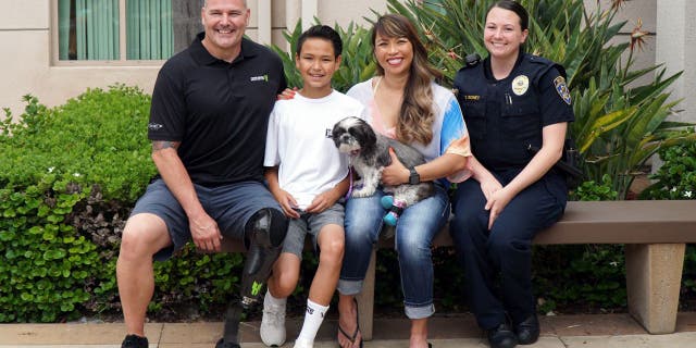 Chappie Hunter and his family found a dog that tugged at their heartstrings. They adopted Chloe, a 9-year-old Shih Tzu with double-amputated back legs. Pictured here are Chappie, Gavin and Arlene Hunter, Officer Boney and dog Chloe. (San Diego Humane Society)