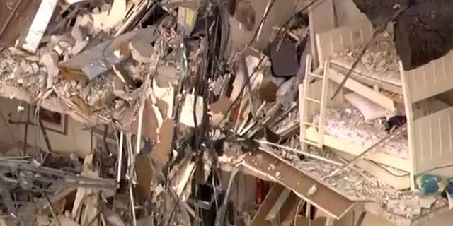 A bedroom is seen in part of the collapsed building.