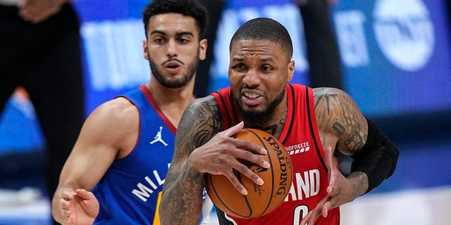Portland Trail Blazers guard Damian Lillard (0) drives to the basket against Denver Nuggets guard Markus Howard during the second half of Game 5 of a first-round NBA playoff series, June 1, 2021, in Denver.