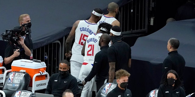 Los Angeles Clippers forward Nicolas Batum, cima, walks through a tunnel in front of center DeMarcus Cousins (15) and guard Patrick Beverley (21) after the Phoenix Suns defeated the Clippers in Game 2 of the NBA basketball Western Conference Finals, martes, junio 22, 2021, in Phoenix. (AP Photo/Matt York)