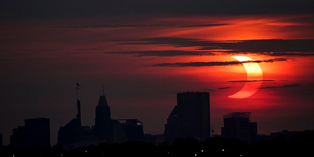 خورشید گرفتگی نسبی ، پنجشنبه ، 10 ژوئن 2021 ، از آربوت ، میشیگان ، بالاتر از افق بالتیمور افزایش می یابد (AP Photo / Julio Cortez)