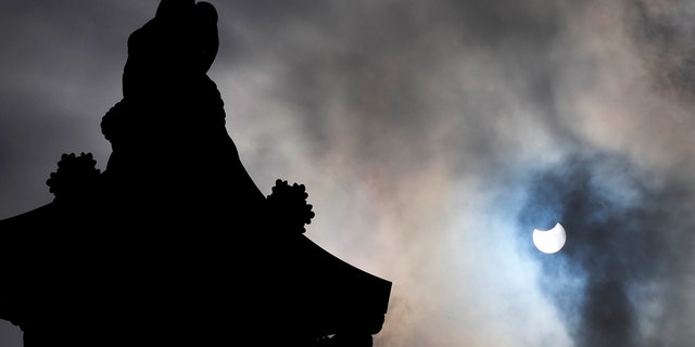 Nelson's Column in Trafalgar Square, London, is silhouetted by a partially eclipsed sun, Thursday June 10, 2021. (AP Photo/Frank Augstein)