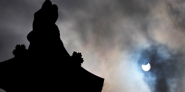 Nelson's Column in Trafalgar Square, London, is silhouetted by a partially eclipsed sun, Thursday June 10, 2021. (AP Photo/Frank Augstein)