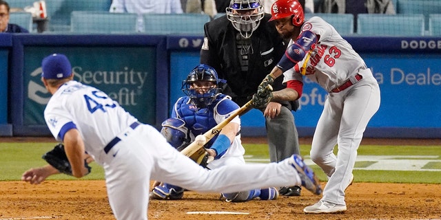 Edmundo Sosa of the St. Louis Cardinals, right, hits an RBI-single while Los Angeles Dodgers solver Blake Treinen, left, and catcher Will Smith, second from left, watch home plate umpire Hunter Wendelstedt in the ninth inning of a game Tuesday June 1, 2021 in Los Angeles. 