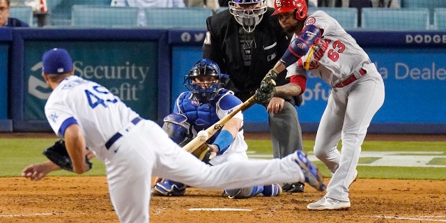 Edmundo Sosa of the St. Louis Cardinals, right, hits an RBI-single while Los Angeles Dodgers solver Blake Treinen, left, and catcher Will Smith, second from left, watch home plate umpire Hunter Wendelstedt in the ninth inning of a game Tuesday June 1, 2021 in Los Angeles.