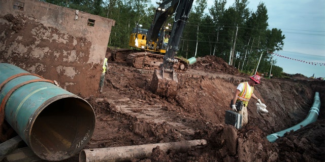 FILE - In this Aug. 21, 2017 file photo, workers make sure that each section of the Enbridge replacement Line 3 that is joined passes muster in Superior, Wisc.  (Richard Tsong-Taatarii/Star Tribune via AP)