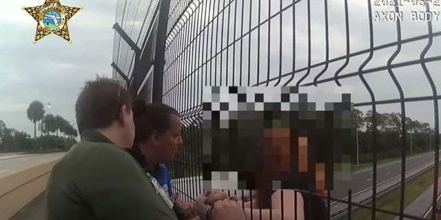 Deputies held the teen's hand after securing her to the railing with handcuffs.