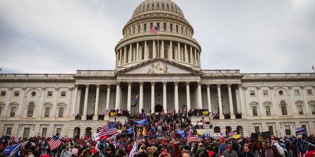 A large group of pro-Trump protesters stands on the East steps of the Capitol Building after storming its grounds on January 6, 2021, in Washington, DC. (Photo by Jon Cherry/Getty Images)
