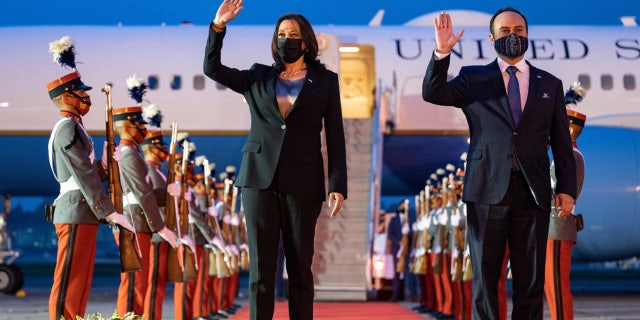 US Vice President Kamala Harris waves alongside Guatemalan Foreign Minister Pedro Brolo upon arrival in Guatemala City on June 6, 2021.