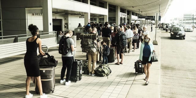 Travelers arrive at the Detroit Metropolitan Wayne County Airport (DTX) in Romulus, Michigan, U.S., on Saturday, June 12, 2021. The acting head of the TSA is reportedly warning that 131 of the largest airports in the U.S. will likely face staffing shortages this month, as air travel begins to pick up amid the nation's Covid-19 recovery. Photographer: Matthew Hatcher/Bloomberg via Getty Images
