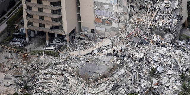 Search-and-rescue personnel with a K-9 unit work in the rubble of a 12-story residential tower that partially collapsed on June 24, 2021, in Surfside, Fla. It is unknown how many people were injured as search-and-rescue effort continues with rescue crews from across Miami-Dade and Broward counties.