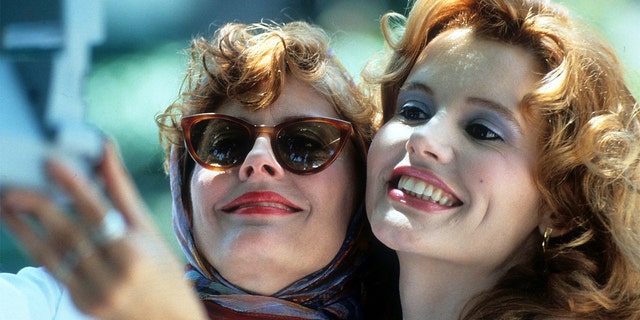 Susan Sarandon and Geena Davis taking Polaroid of themselves in a scene from the film 'Thelma &amp; Louise', 1991. 