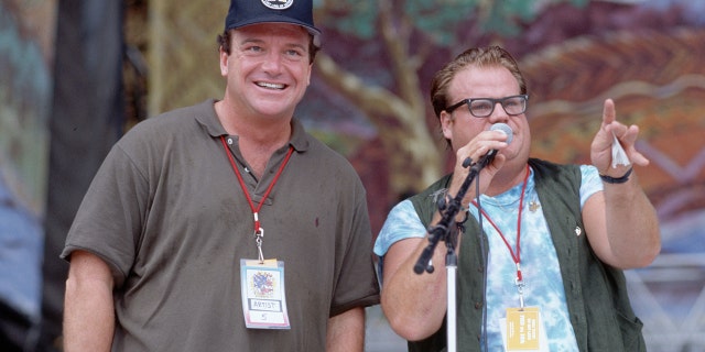 Chris Farley (right) and Tom Arnold on the stage at the 25th Anniversary concert for the celebration of the original Woodstock concert.