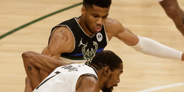 Milwaukee Bucks forward Giannis Antetokounmpo, top, guards against Brooklyn Nets' Kevin Durant during the second half of Game 6 of a second-round NBA basketball playoff series Thursday, June 17, 2021, in Milwaukee. (AP Photo/Jeffrey Phelps)