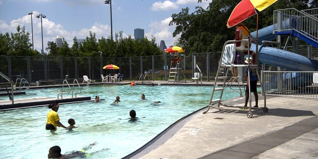 People swim at Emancipation Park during a heatwave in Houston, Texas, NOSOTROS., El miércoles, junio 16, 2021. Temperatures are expected to reach 98 degrees Fahrenheit in Houston as a heat wave that's expected to drag on through the end of the week blankets the western half of the U.S.