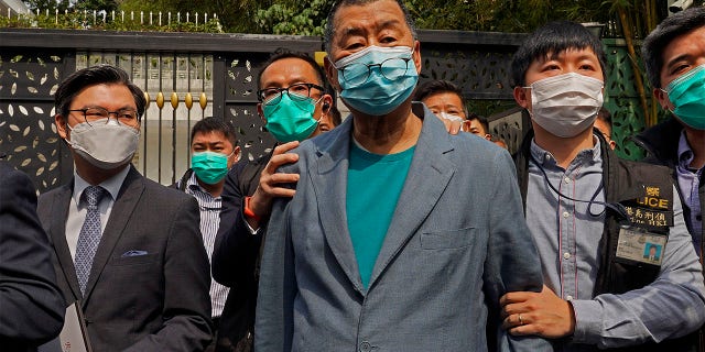 FILE - In this April 18, 2020, file photo, Hong Kong media tycoon Jimmy Lai, center, who founded local newspaper Apple Daily, is arrested by police officers at his home in Hong Kong.